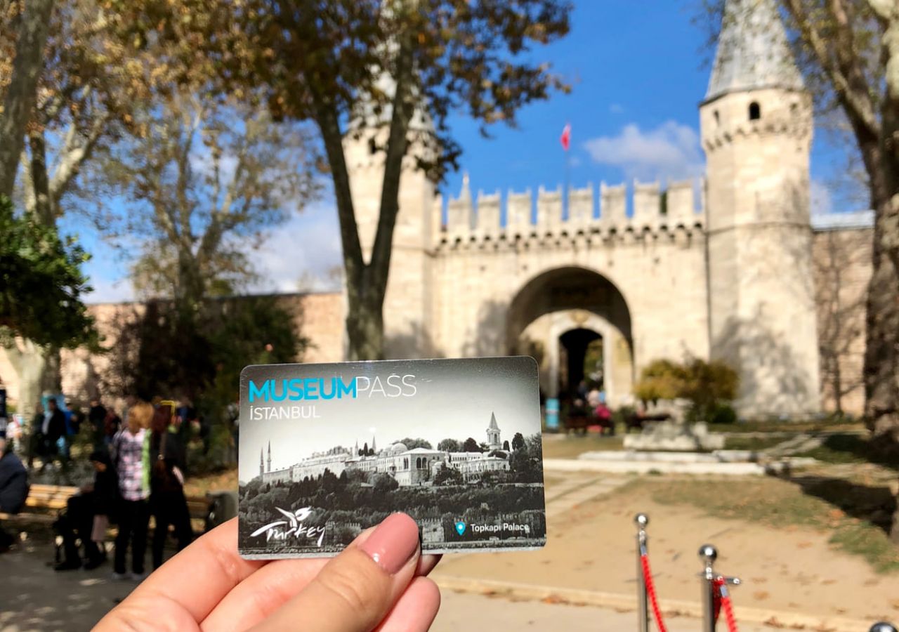 eine Hand hält einen Museumspass vor dem Topkapi-Palast